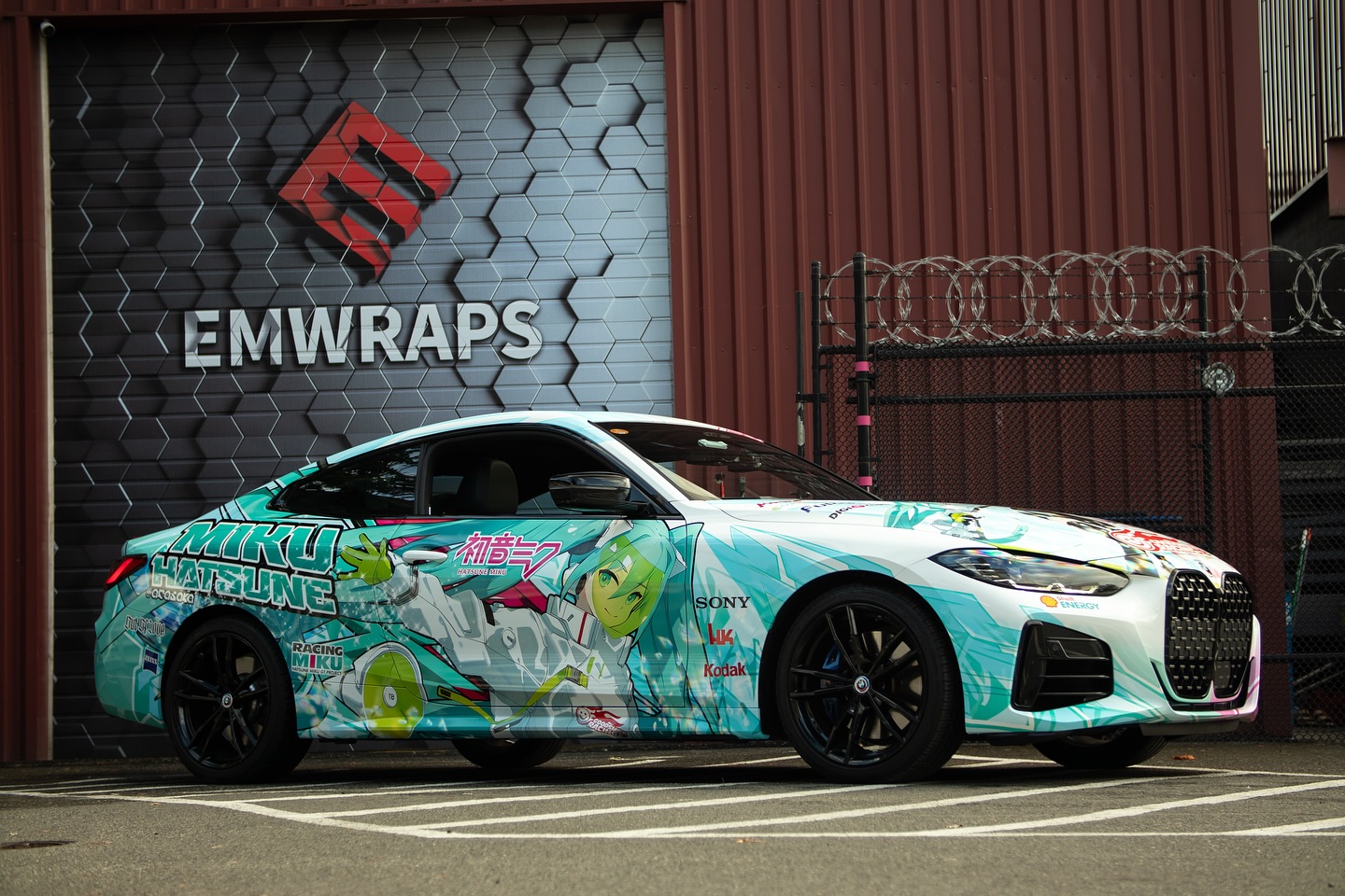 Full body Hatsune Miku Racing livery on a BMW 430i in front of EMWRAPS